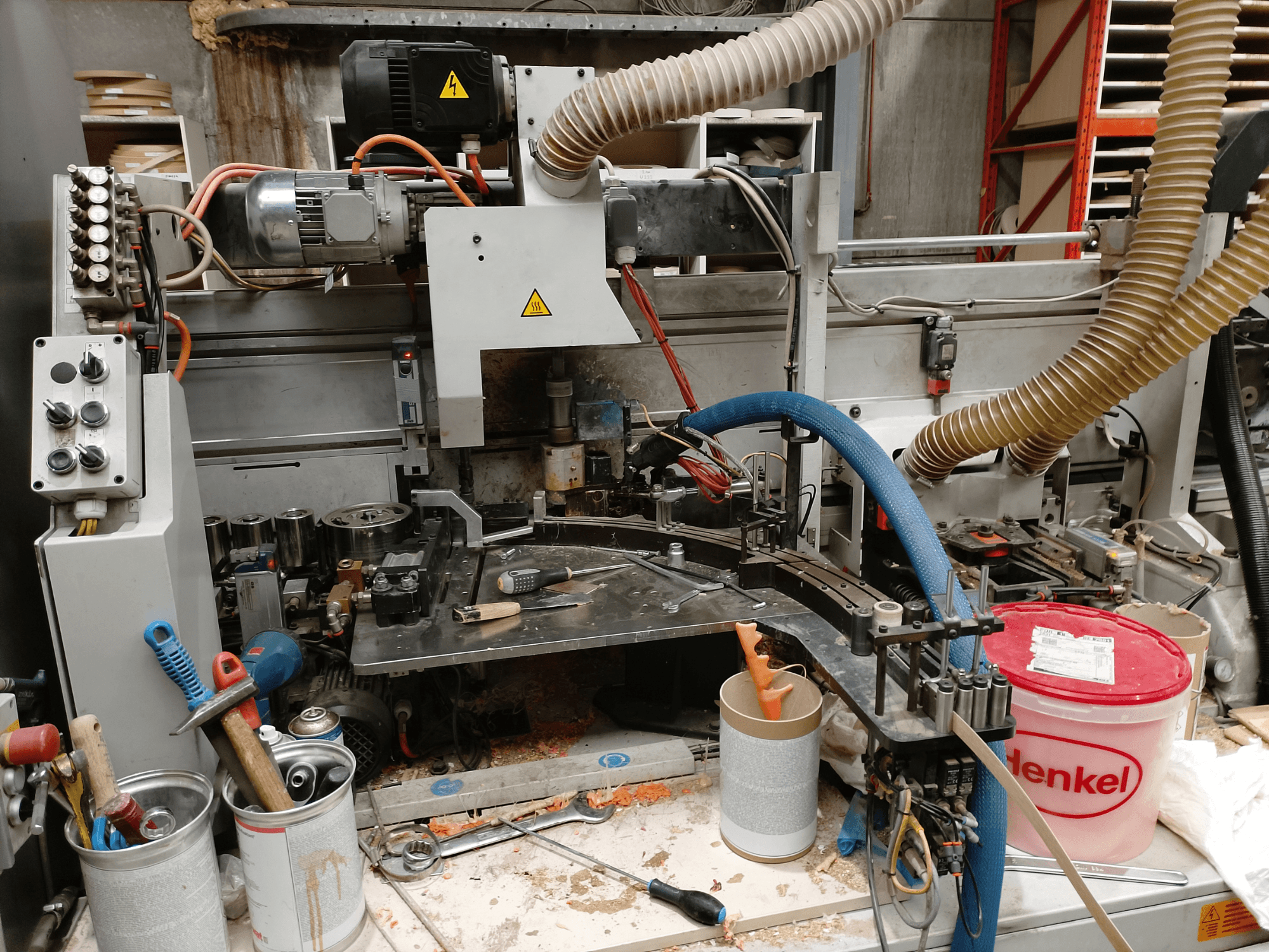 BIESSE Edge Stram B1 rubna traka u prednjem pogledu, s prikazom strojeva, crijeva i radnog alata usred strugotine drva.