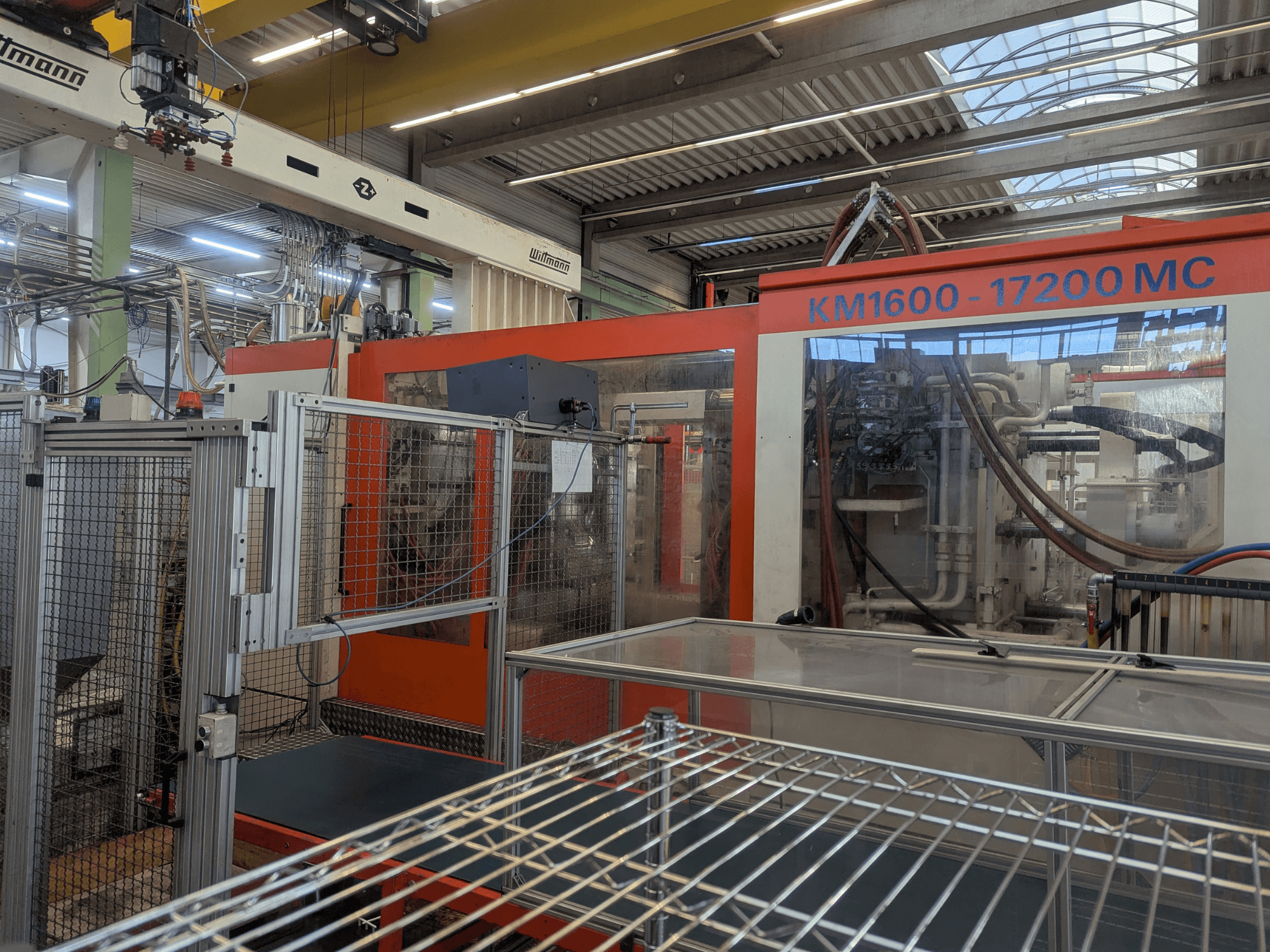 Hidraulički stroj za brizganje plastike Krauss Maffei KM 1600-17200MC, prednji pogled s vidljivom upravljačkom pločom i hidrauličkim vodovima.