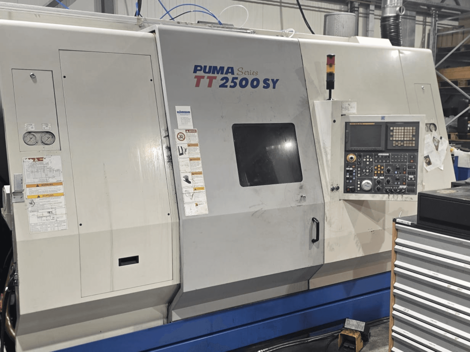 PUMA serija TT 2500 SY CNC tokarski stroj, pogled sprijeda; upravljačka ploča s brojčanicima i gumbima, mjeračima i vidljivim oznakama rada.