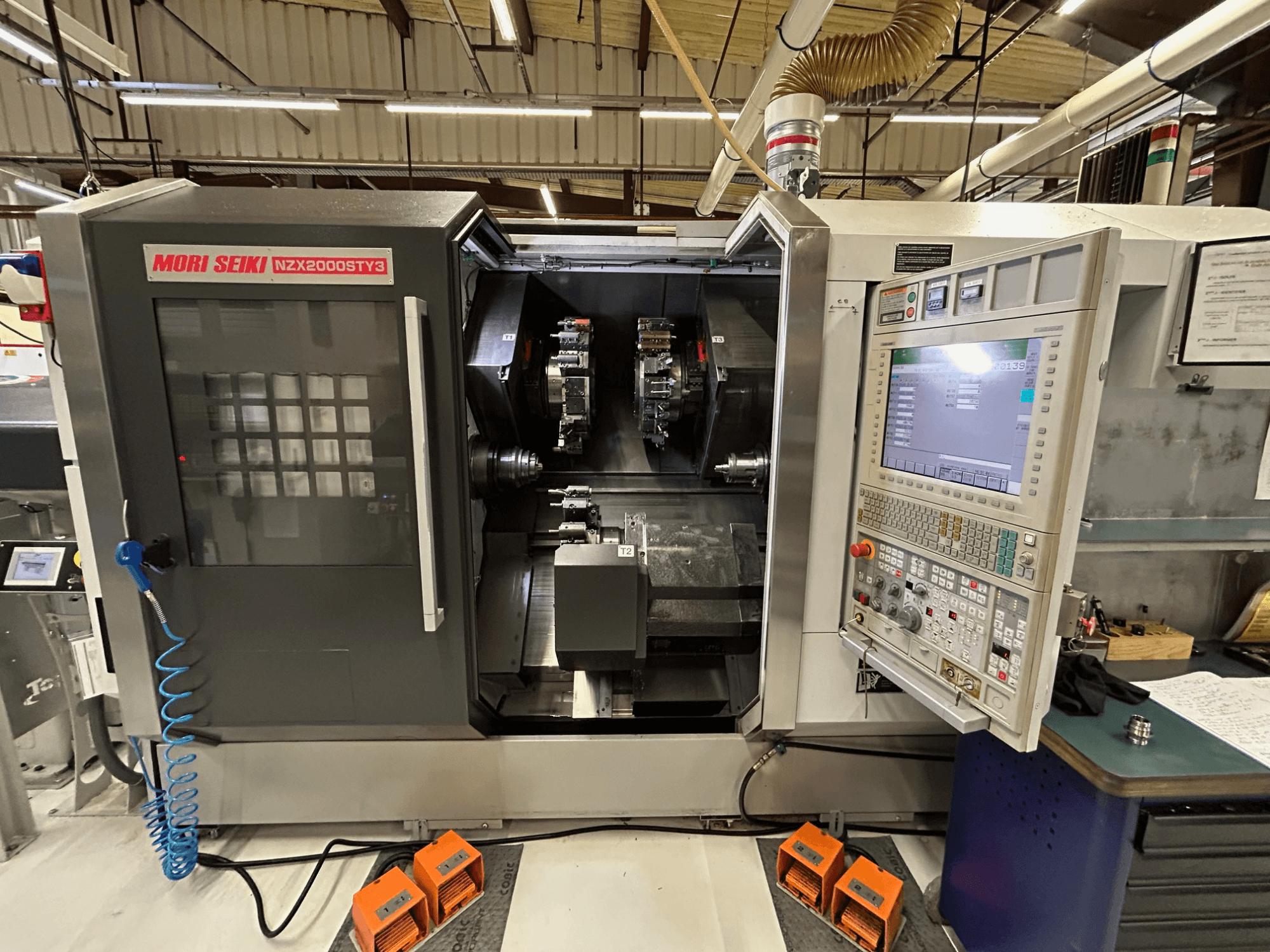 MORI SEIKI NZ2000 ST3Y3 viševretenski tokarski stroj, prednji pogled s upravljačkom pločom i područjem obrade.
