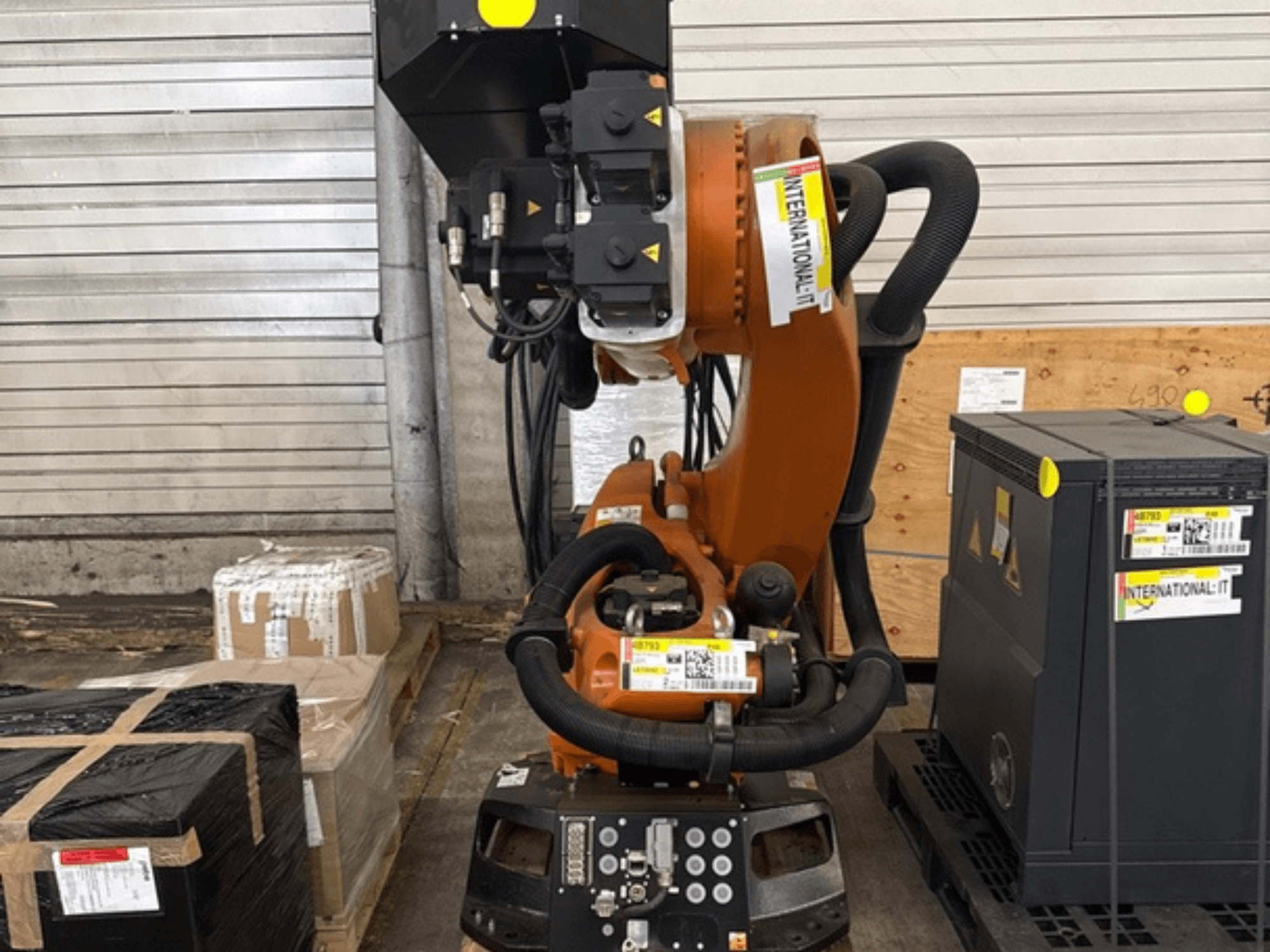 Dodatna robotska ruka KUKA KR 210 R2700 u prednjem pogledu, izložena na paleti pored paketa i opreme.