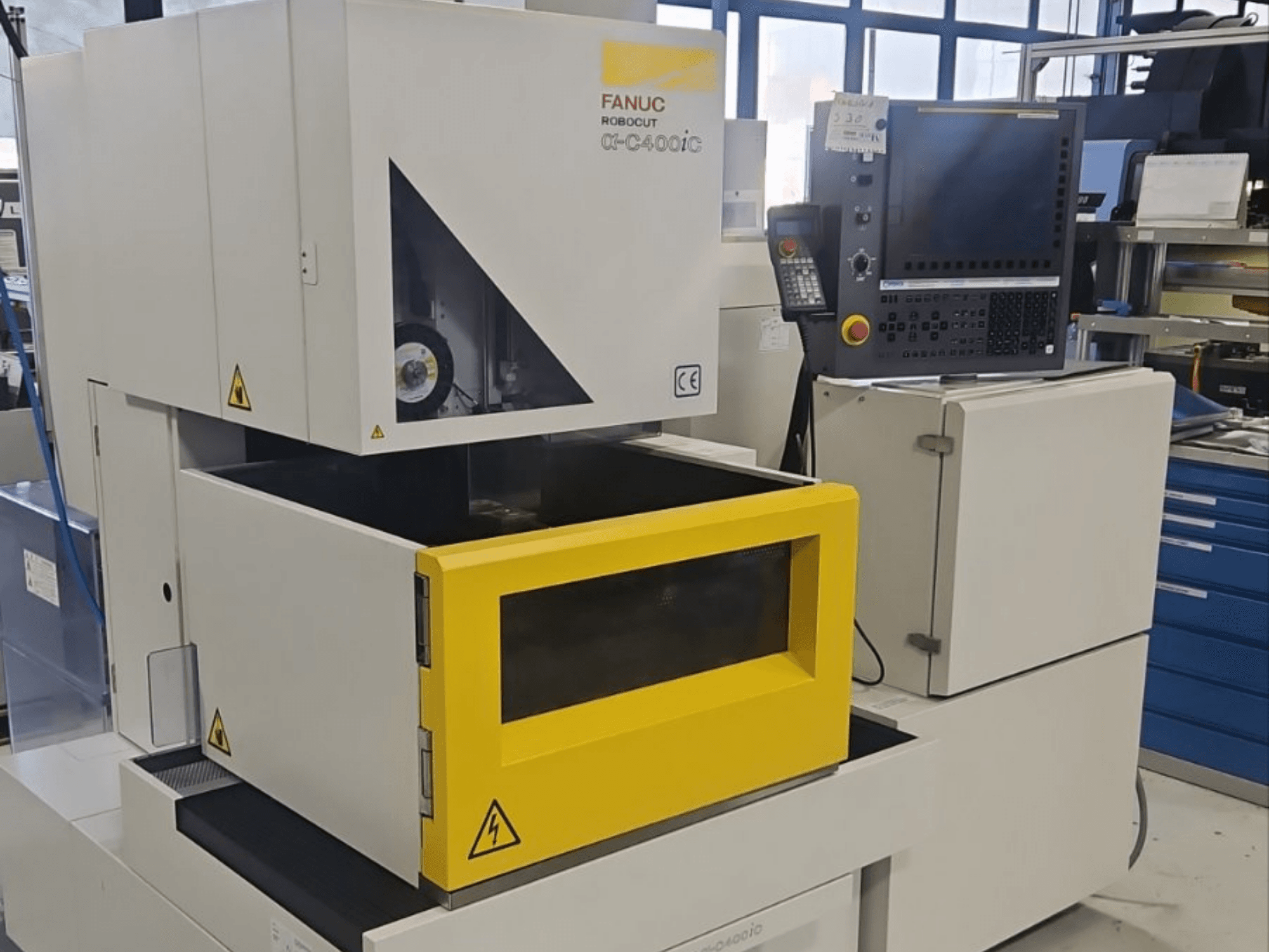 FANUC Robocut alpha-C400iC EDM stroj za udubljivanje u prednjem pogledu, sa žutom komorom za obradak i upravljačkom pločom.