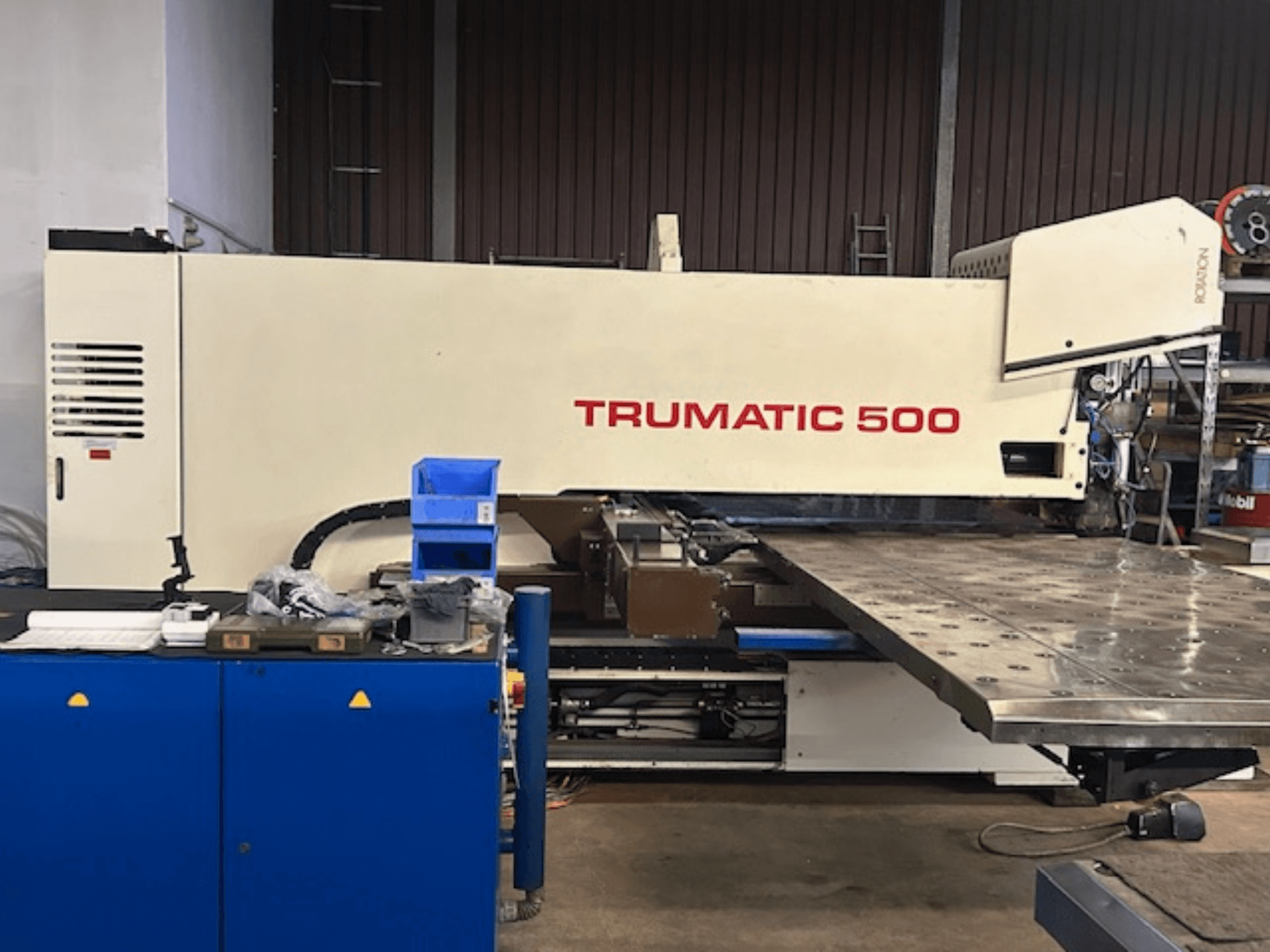 TRUMPF TRUMATIC 500 CNC stroj za probijanje, prednji pogled, s upravljačkom pločom i velikim radnim stolom s perforiranom površinom.