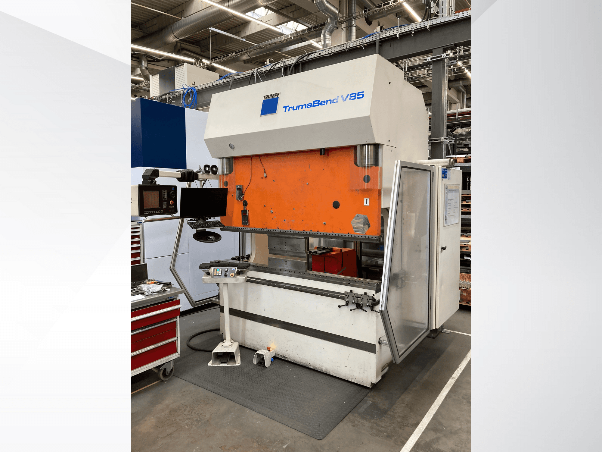 Stroj za savijanje TruMatic V85 u tvornici s narančastom prednjom pločom, upravljačkim zaslonom i otvorenim bočnim vratima, bočni pogled.